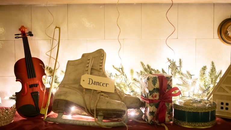 Image shows ice skating shoes, a violin and wrapped presents as part of Father Christmases toy making area at Saltram
